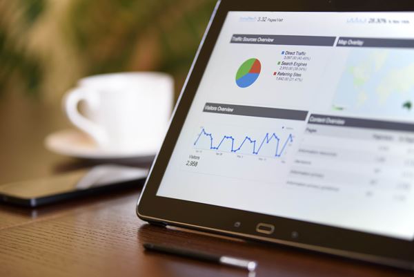 charts analytical data tablet screen with cup coffee telephone background